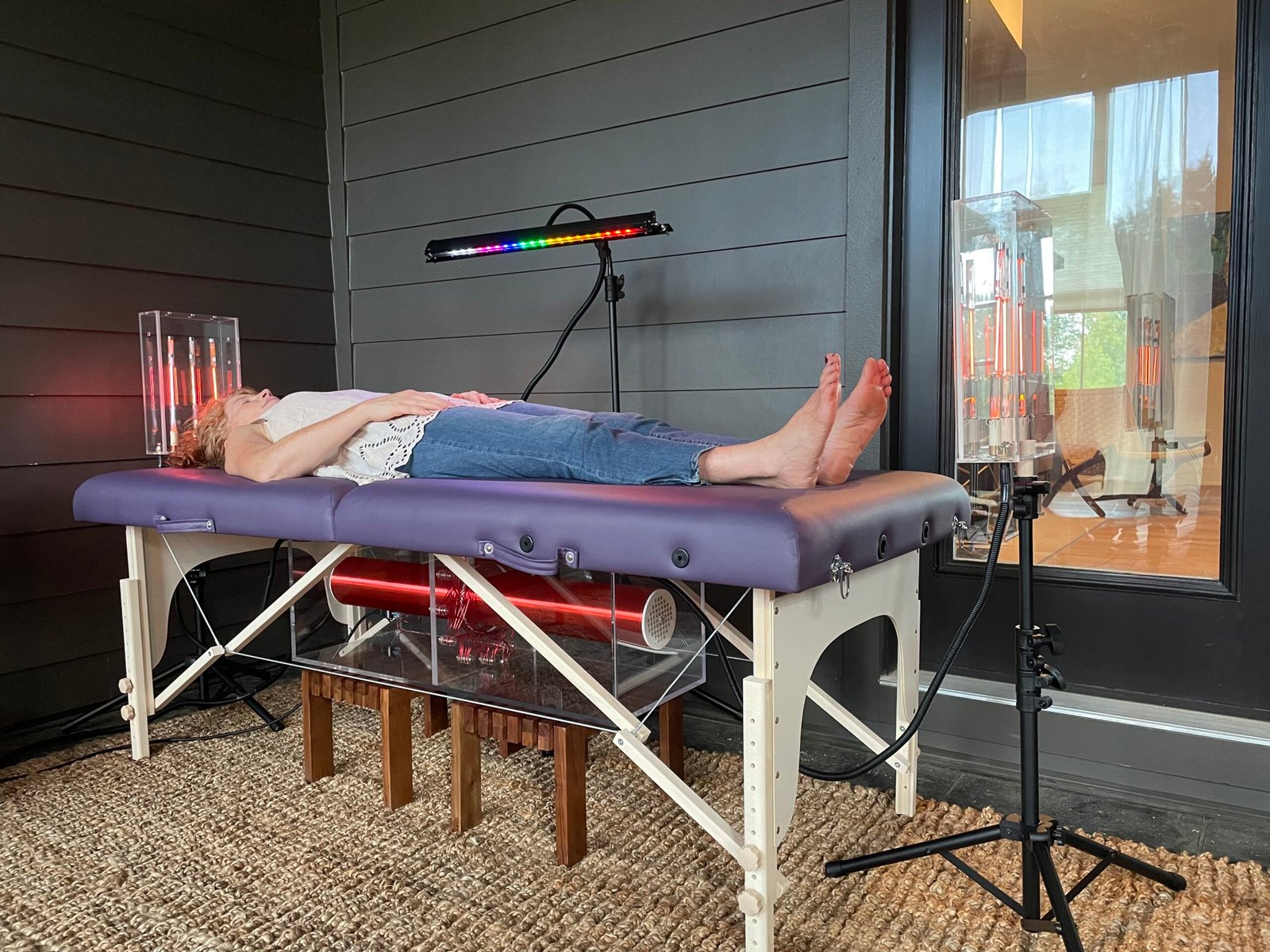 Woman receiving frequency healing on the Tesla Wellness Table — chromotherapy and plasma light therapy