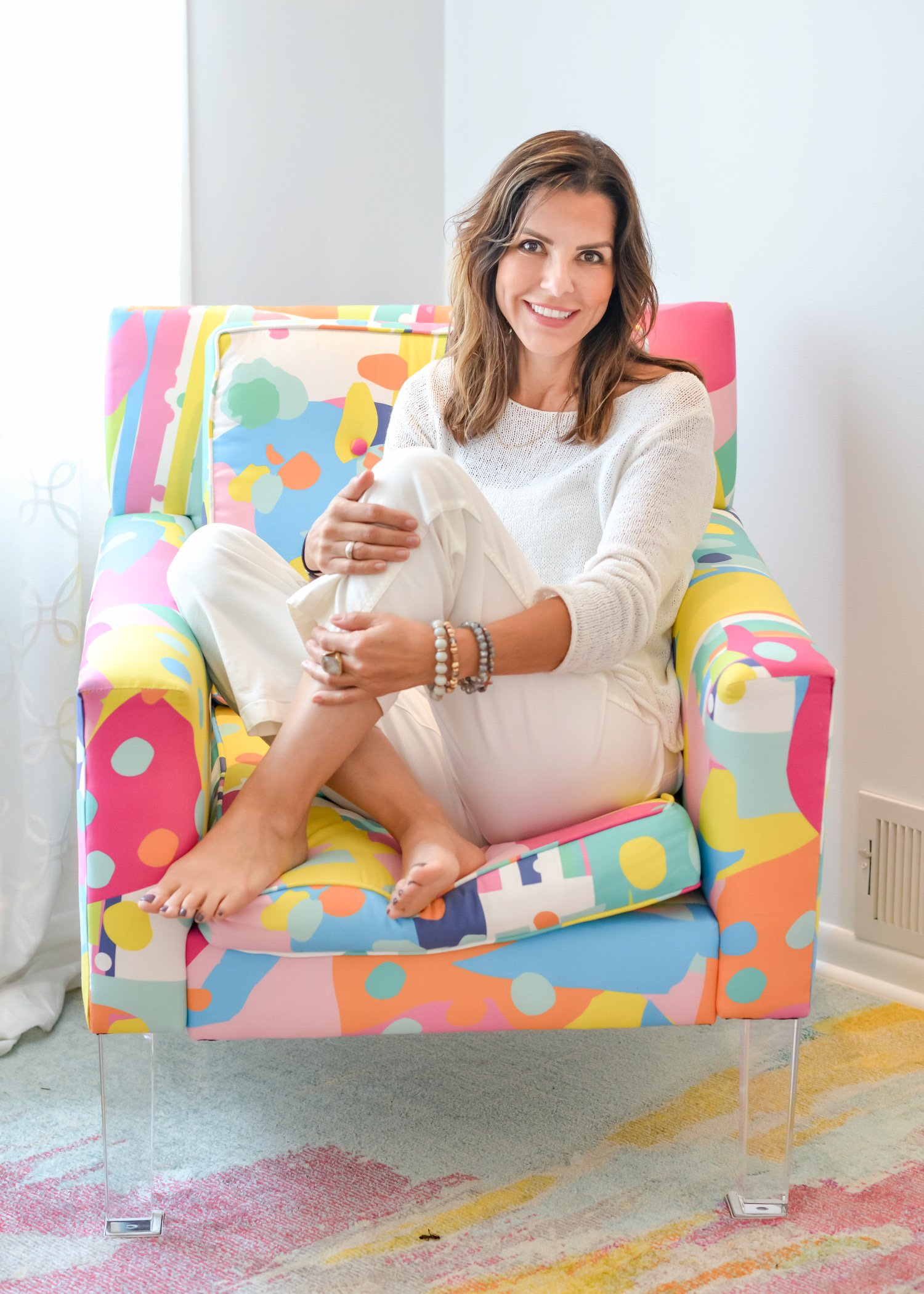 Victoria — founder of The Healing Frequency Space, seated in a colorful chair